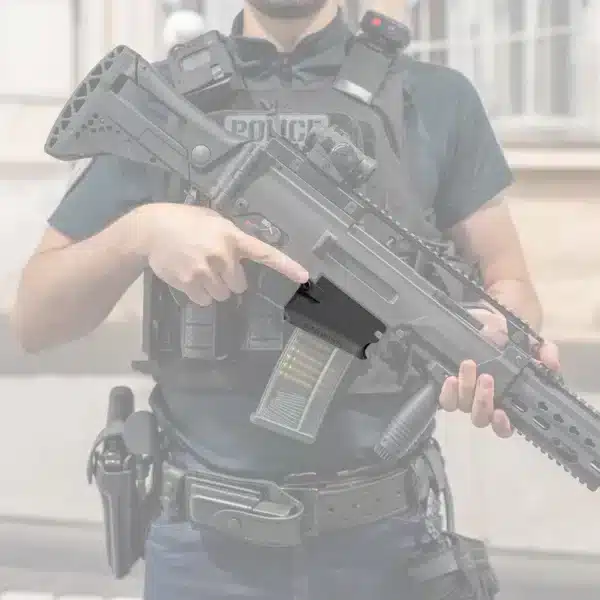 Policier debout tenant une carabine HK G36 équipée d'un viseur point rouge et d'un magwell